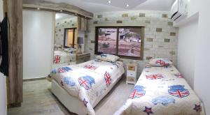 a bedroom with two beds and a mirror at wonderful duplex at Solemar resort Kaslik-Jounieh in Jounieh