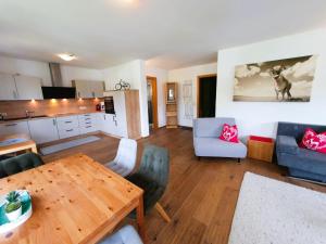 a living room with a table and a kitchen at Appartement "Alpking" in Ellmau