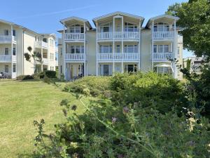 un grande condominio con un prato di fronte di Haus Rügenscher Bodden Whg 8 und Whg 9 mit Meerblick a Göhren