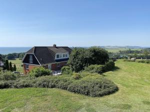una casa in cima a una collina erbosa di Haus Rügenscher Bodden Whg 8 und Whg 9 mit Meerblick a Göhren