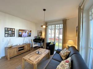 a living room with a couch and a table and a piano at Haus Strandkiefer in Baabe