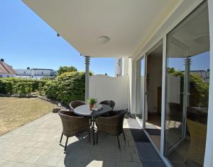 un patio con tavolo e sedie su un patio di Haus Möwe II - Whg 01 mit Terrasse a Ostseebad Sellin Altre 23 foto