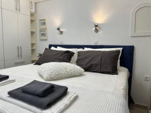 a bed with black and white sheets and pillows on it at Sunnyside Suite Afytos in Afitos
