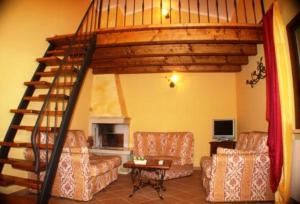 a living room with a spiral staircase in a house at Agriturismo Le Rose in Pescia Romana