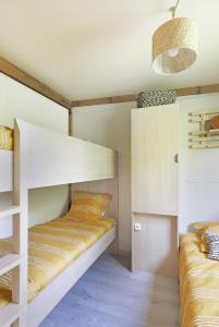 Un ou plusieurs lits dans un hébergement de l'établissement Les Chalets de Moulière