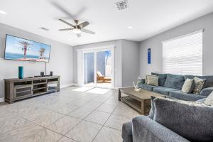 Indian Harbour BeachにあるFortebello Beachside 170 With PRIVATE POOLのソファと天井ファンのあるリビングルーム