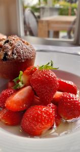 einen Teller mit Erdbeeren und einem Muffin und einem Cupcake in der Unterkunft Hôtel-Restaurant La Mascotte in La Baule