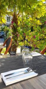 einen Tisch mit Besteck auf einem Tisch in der Unterkunft Hôtel-Restaurant La Mascotte in La Baule