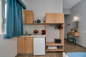 a small kitchen with wooden cabinets and a sink at Laconia Domus - Plytra in Plytra