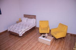 Résidence GESAM في Sabalibougou: غرفة نوم بسرير وكرسي اصفر