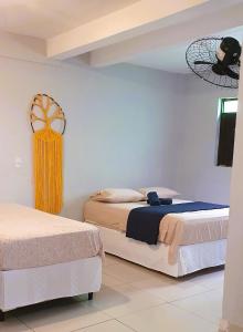 a bedroom with two beds and a fan at Espaço Jardim Secreto Hospedaria in João Pessoa