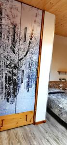 ein Zimmer mit einer Glastür mit einem Gemälde darauf in der Unterkunft Trilocale mansardato nel cuore della Val Di Fiemme in Ziano di Fiemme