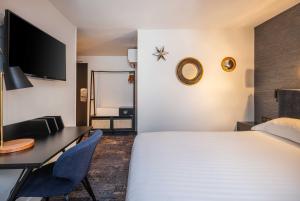 una camera d'albergo con letto e scrivania di Hotel Marena a Parigi