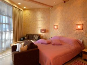 a bedroom with a bed with pillows and a couch at Boutique Hotel Light House Jurmala in Jūrmala