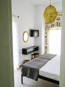 埃爾莫波利斯的住宿－Axilleion Guest House，一间卧室配有一张大床和镜子