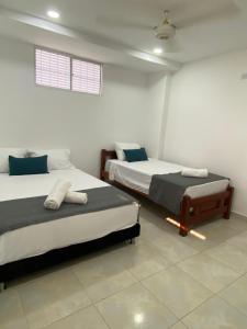 a room with two beds and a window at 22 Guest House in Santa Marta +11 photos