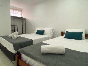 a room with two beds with blue pillows at 22 Guest House in Santa Marta