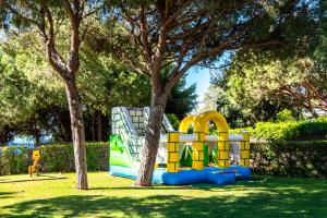 a playground in a park next to a tree at Charm Apartment T2 All With Big Terrace Albufeira Self check-in in Albufeira