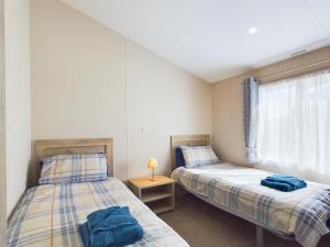 2 łóżka pojedyncze w pokoju z oknem w obiekcie E7 Roebeck Country park w mieście Ryde