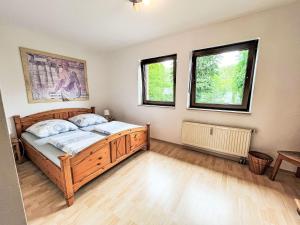 1 dormitorio con 1 cama de madera y 2 ventanas en Apartment Ferienapartments Adenau-2 by Interhome, en Adenau