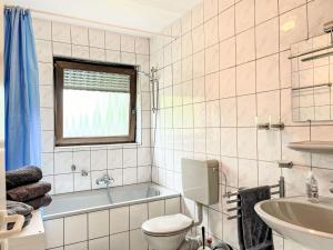 Apartment Ferienapartments Adenau-2 by Interhome في آدناو: حمام مع حوض ومرحاض ومغسلة