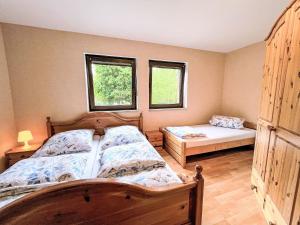 a bedroom with two beds and two windows at Apartment Ferienapartments Adenau-2 by Interhome in Adenau