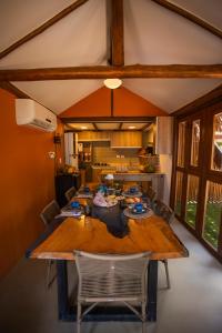 uma grande mesa de madeira num quarto com uma cozinha em Casa Conceição em Fernando de Noronha