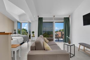 a living room with a couch and a bed and windows at Stonehouse Residence in Makarska