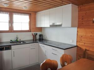 Haslen的住宿－阿爾卑施泰因山景公寓，厨房配有白色橱柜和木墙
