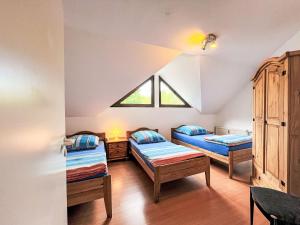 a attic room with two beds and a window at Apartment Ferienapartments Adenau-4 by Interhome in Adenau