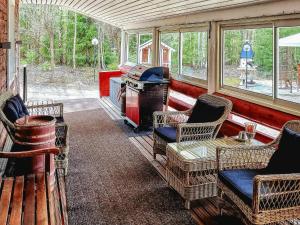 una veranda riparata con sedie e piano cottura di Holiday Home Minervahovi by Interhome a Pääjärvi