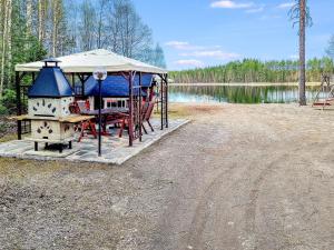 un gazebo con sedie, un tavolo da picnic e un lago di Holiday Home Minervahovi by Interhome a Pääjärvi