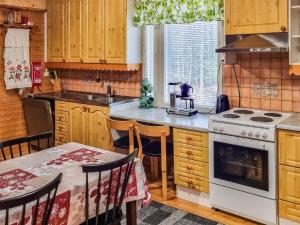 una cucina con piano cottura e tavolo con sedie di Holiday Home Minervahovi by Interhome a Pääjärvi