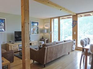 a living room with a couch and a television at Apartment Roossi Apt- 1 by Interhome in Wengen