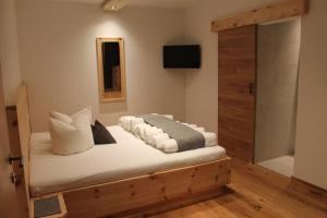 1 dormitorio con 1 cama con almohadas blancas en Haus Hermine, en Umhausen
