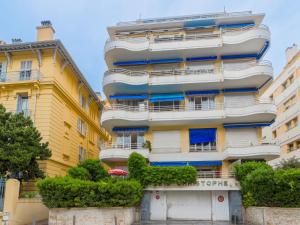 un edificio alto de color amarillo con ventanas azules en Apartment Saint Christophe by Interhome, en Niza