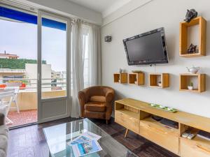 a living room with a tv and a chair and a table at Apartment Saint Christophe by Interhome in Nice