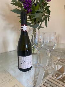 a bottle of wine sitting on a table with glasses at Beautiful stone cottage in peaceful village in Richmond