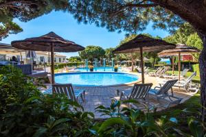 a pool with chairs and umbrellas at Charm Apartment T2 All With Big Terrace Albufeira Self check-in in Albufeira