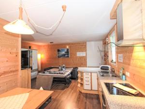 a kitchen and living room with wooden walls at Apartment Barbara-2 by Interhome in Fügen