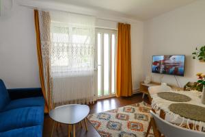 uma sala de estar com um sofá azul e uma mesa em Apartament Corina cu parcare em Bistriţa