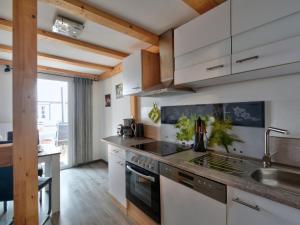 een keuken met witte kasten en een fornuis met oven bij Holiday Home Ferienhaus Born by Interhome in Schieder-Schwalenberg