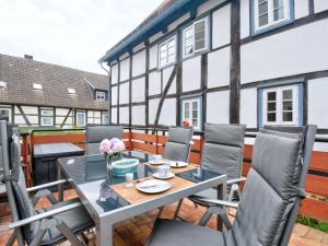 Holiday Home Ferienhaus Born by Interhome في Schieder-Schwalenberg: فناء مع طاولة وكراسي ومبنى