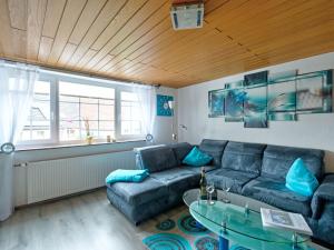 a living room with a blue couch and a glass table at Holiday Home Ferienhaus Born by Interhome in Schieder-Schwalenberg +44 photos