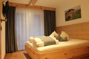 1 dormitorio con cama de madera y ventana en Haus Hermine, en Umhausen