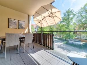 eine Terrasse mit einem Tisch, Stühlen und einem Sonnenschirm in der Unterkunft Apartment Willa Maria by Interhome in Polanica-Zdrój