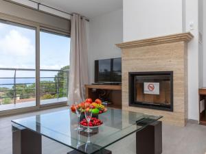 a living room with a glass table and a fireplace at Villa Palmbeach by Interhome in Lloret de Mar