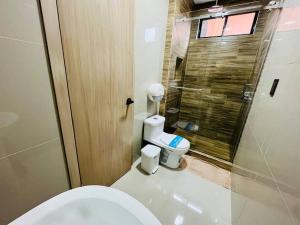 a bathroom with a toilet and a glass shower at Departamento 2 Habitaciones con Balcón a 10min Consulado Americano in Guayaquil