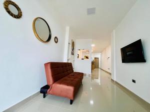 a living room with a red chair and a mirror at Departamento 2 Habitaciones con Balcón a 10min Consulado Americano in Guayaquil