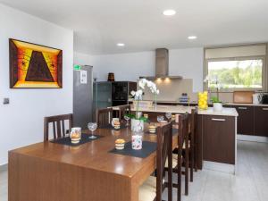 a kitchen and dining room with a wooden table and chairs at Villa Palmbeach by Interhome in Lloret de Mar +37 photos
